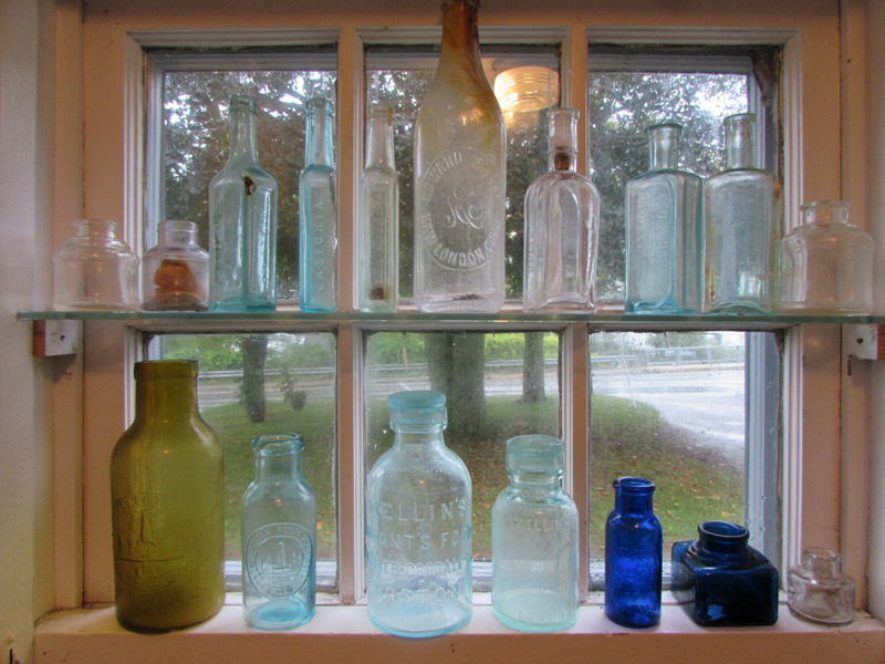 Bottles from 100 years ago on display at the Woods Hole Historical Museum that were collected by Becky Lash, who will tell about them October 11. (Photo by Robert Grosch)